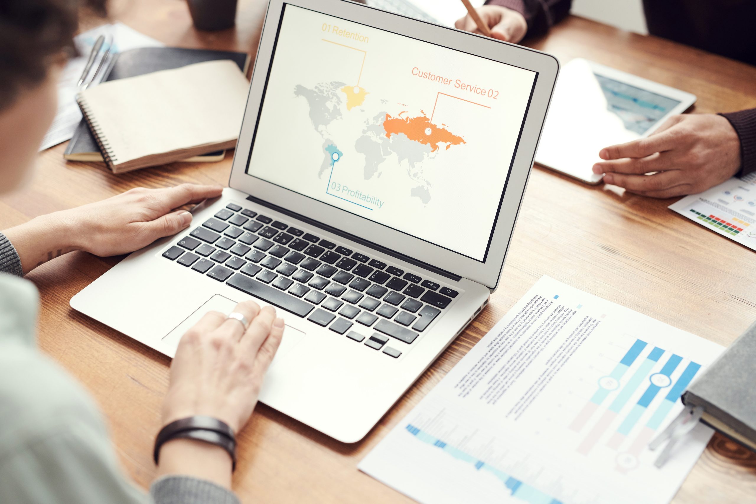 business person on computer looking at international map of the world and charts. Overcoming International Business Hurdles
