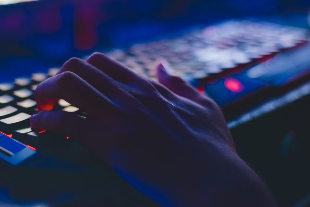 photo of a hand hovering over a computer utilizing cloud-based solutions